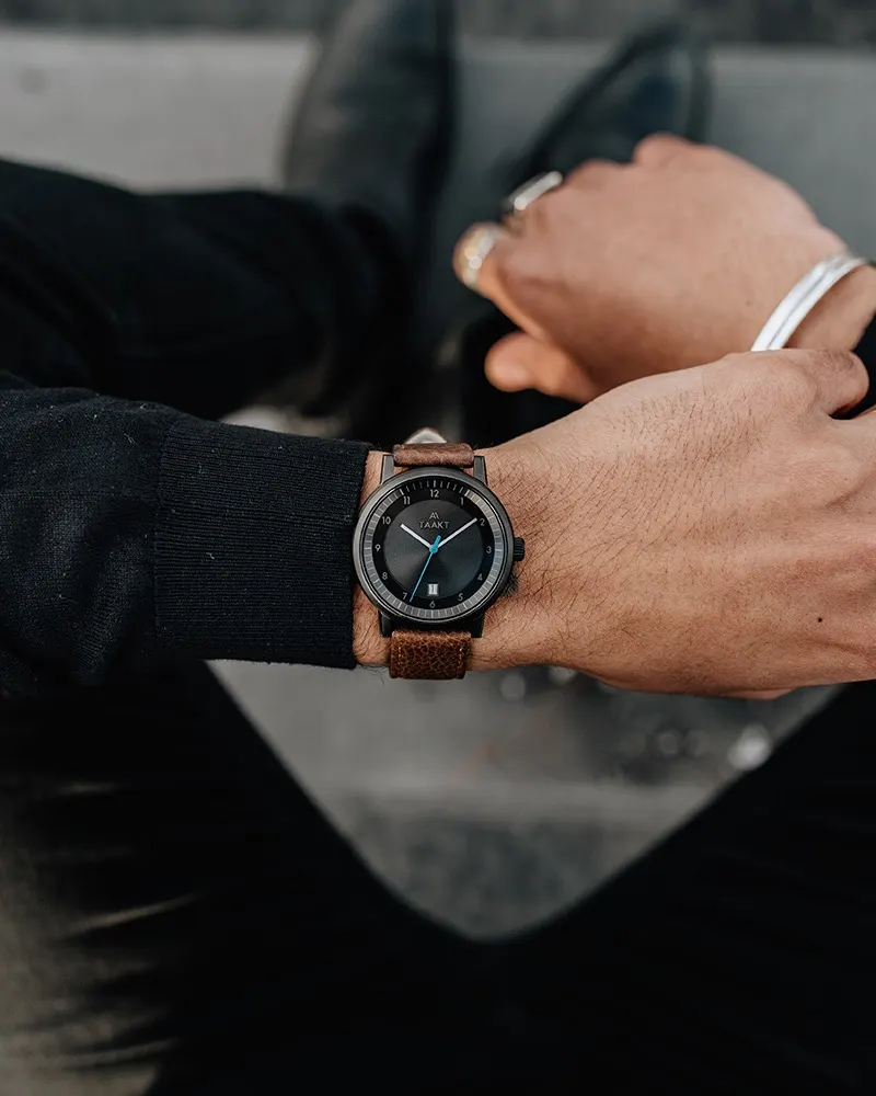 A black Aspect on brown leather, worn sitting on concrete steps